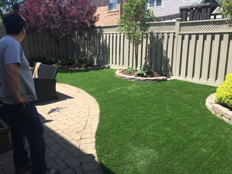 Curved artificial lawn edged with garden beds