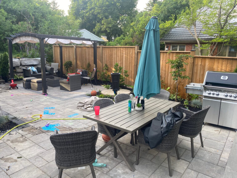 A dining patio with umbrella and barbecue