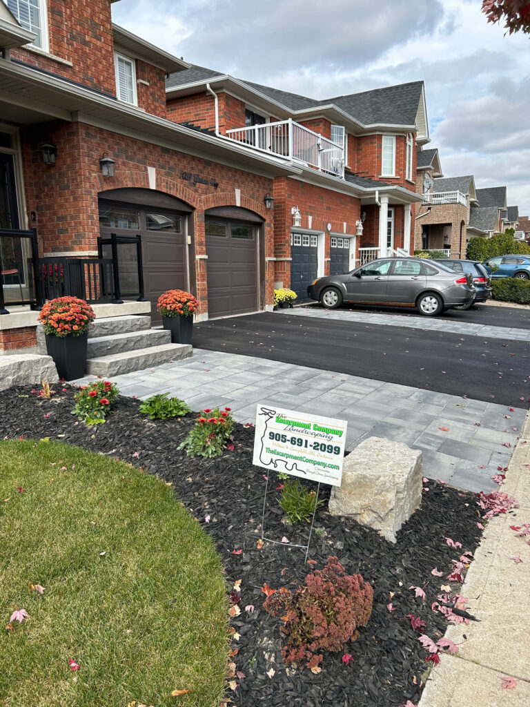 A front yard with armour stone, mulch beds and a new walkway