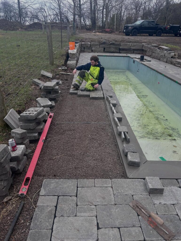 Pool coping and stone being set, before the deck was finished