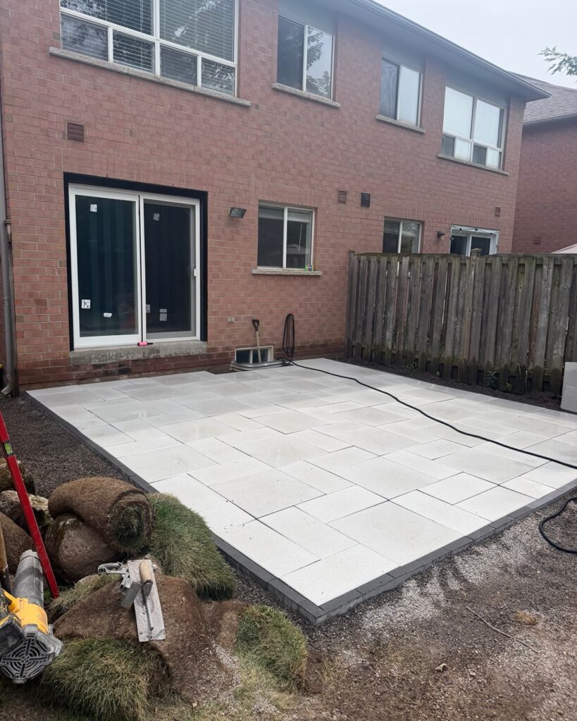Slab patio being laid with rolls of sod waiting