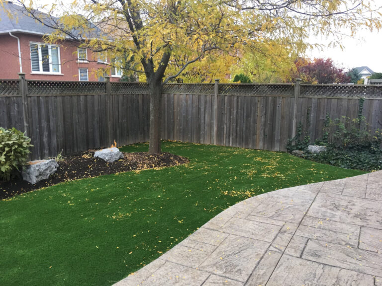 A curved stamped path through a fenced lawn in autumn