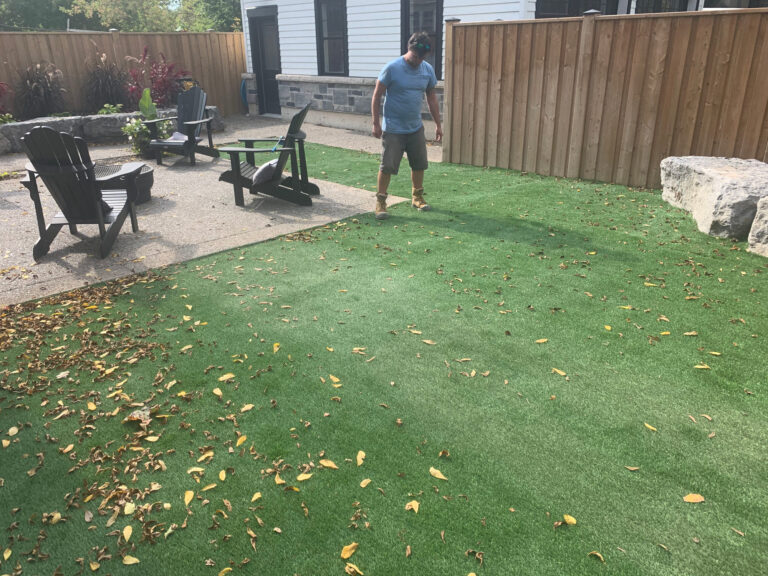 Muskoka chairs on turf beside armour stone