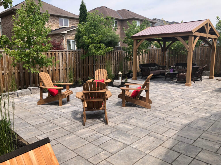 Muskoka chairs under a pergola on a stone patio