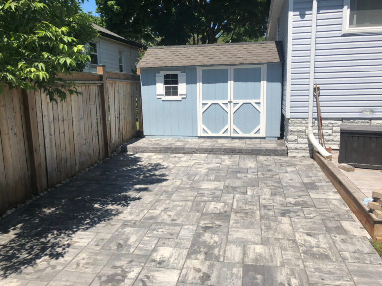 A paver patio in front of a garden shed