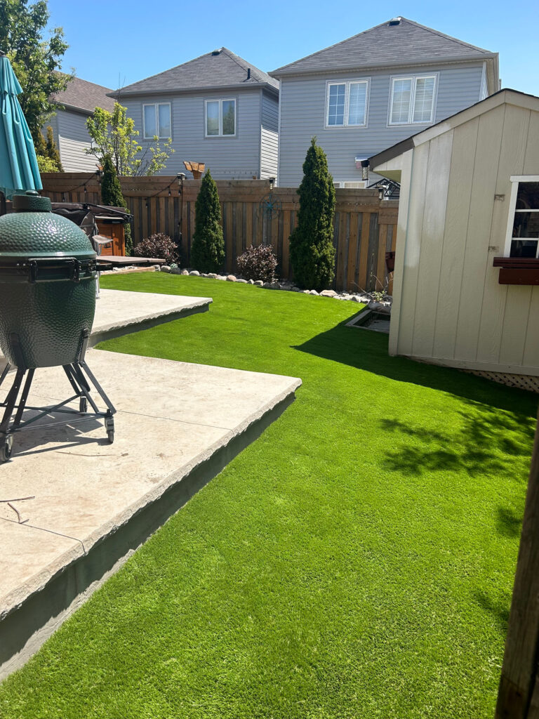 Turf meeting a stamped concrete patio beside a shed