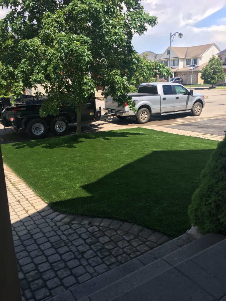 Turf with a cobblestone border by the driveway